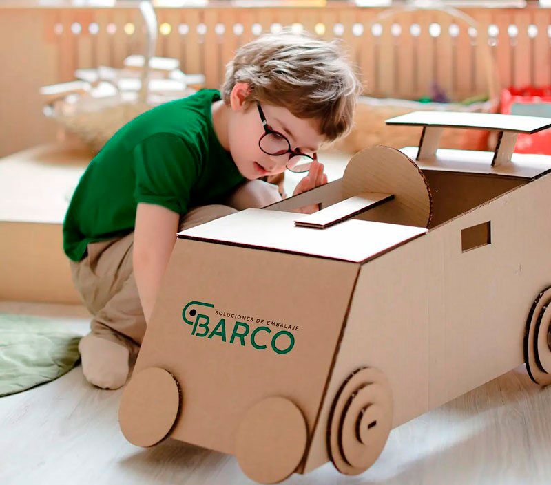 Niño jugando con una manualidad hecha con una caja de cartón