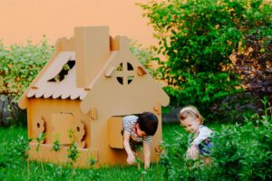 los-ninos-estan-jugando-en-una-casa-de-carton-el-nino-se-esta-divirtiendo-al-aire-libre