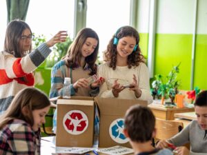 niñas en clase con cajas de cartón reciclando
